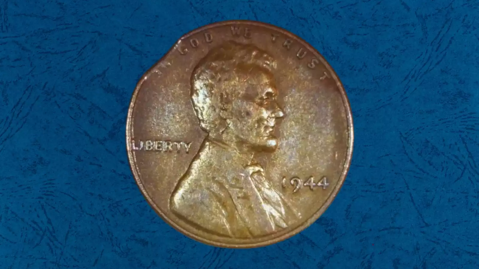 1944 wheat penny clipped planchet error showing curved section missing from coin edge caused by punch-over during blank cutting